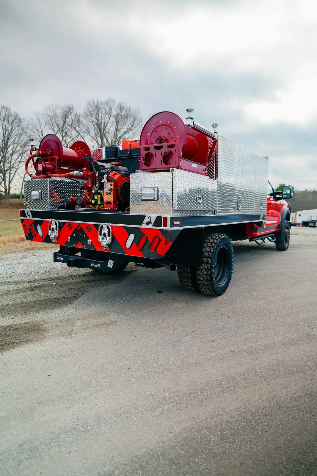 Rear view of an FES brush truck skid unit with pump, plumbing, and dual hose reels