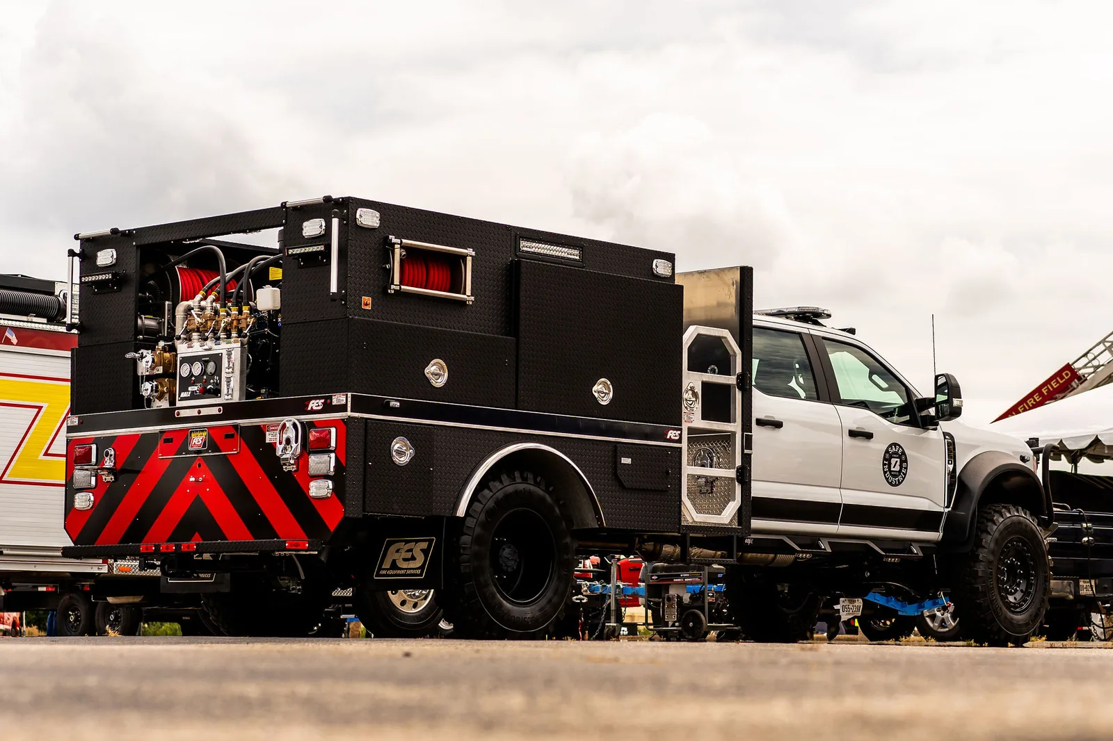 Black FES skid unit body with pump and hose reel mounted on a crew cab chassis